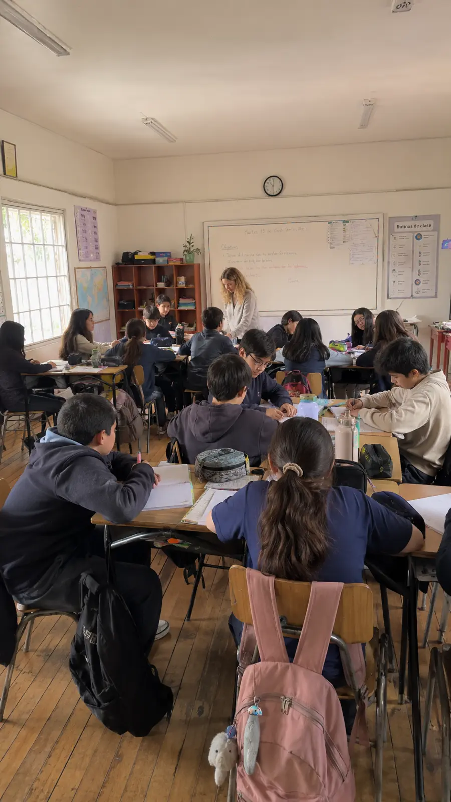 Docente trabajando con estudiantes en una sala de clases chilena
